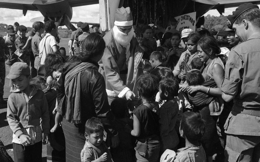 Santa Claus hands out presents to children, dependents of South Vietnamese Special Forces soldiers stationed at Nhon Cho. Some Montegnard children from the area also joined in the fun.