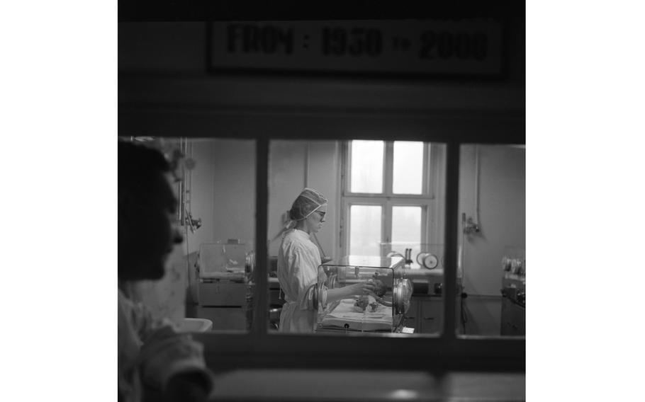 Unidentified nurse feeds a premature baby.