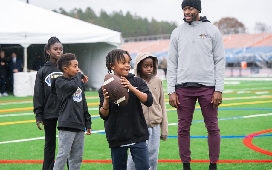 Local kids and caregivers from military and veteran families participate in the QB arm accuracy drill