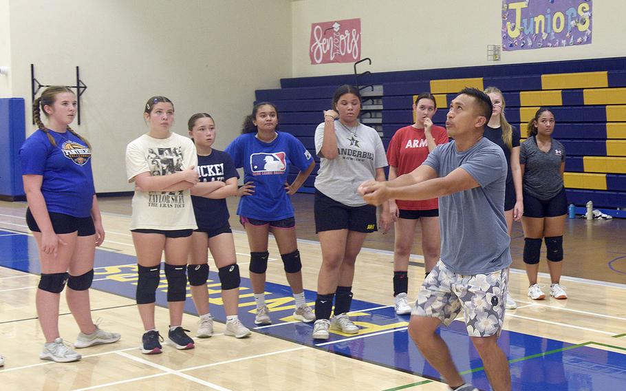 Emmanual Miquel, Yokota assistant volleyball coach, demonstrates passing the ball during Monday's first day of practice for the defending Far East Division II champion Panthers.