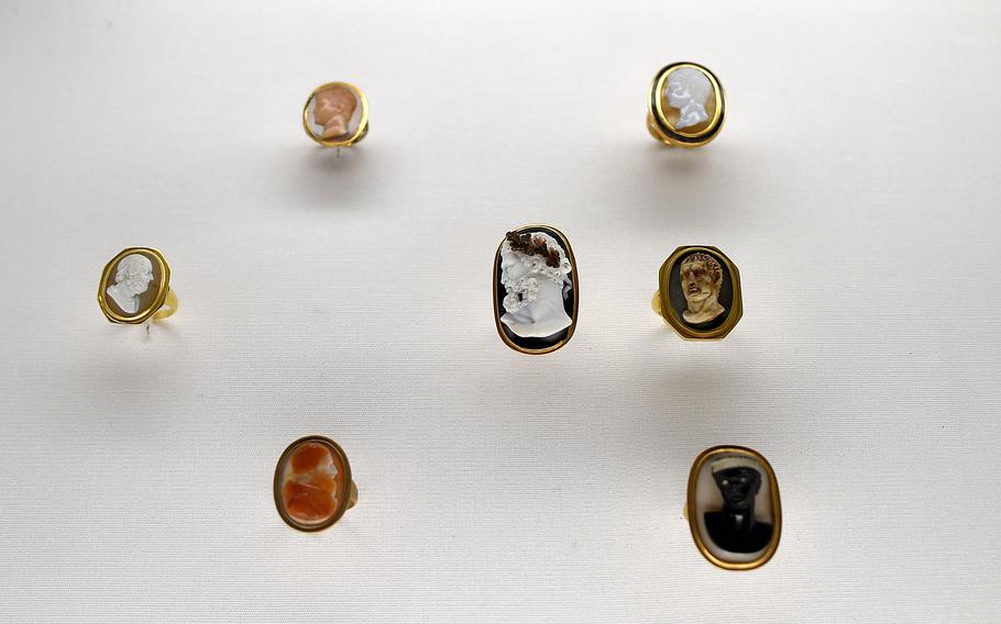 The Pforzheim Jewelry Museum in Pforzheim, Germany, displays these neoclassical image rings from the late 18th and early 19th centuries from Italy. Among the historical figures depicted are Homer, far left; perhaps of a young Ancient Roman Emperor Nero, top left; Roman general Germanicus, center; and Roman emperor Augustus, top right.