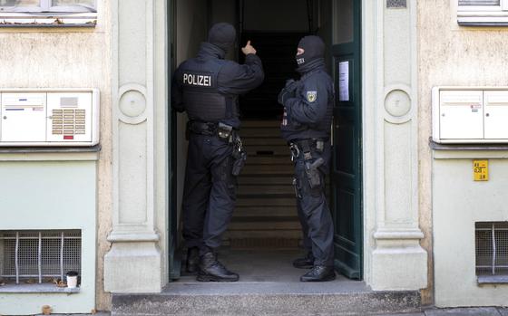 Police officers stand in a building entrance during a raid against suspected members of a far-right militant organization in Dresden, Germany, Nov. 5, 2024. (Sebastian Kahnert/dpa via AP)