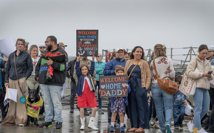 Friends and family wait for the USS O’Kane to pull into its homeport