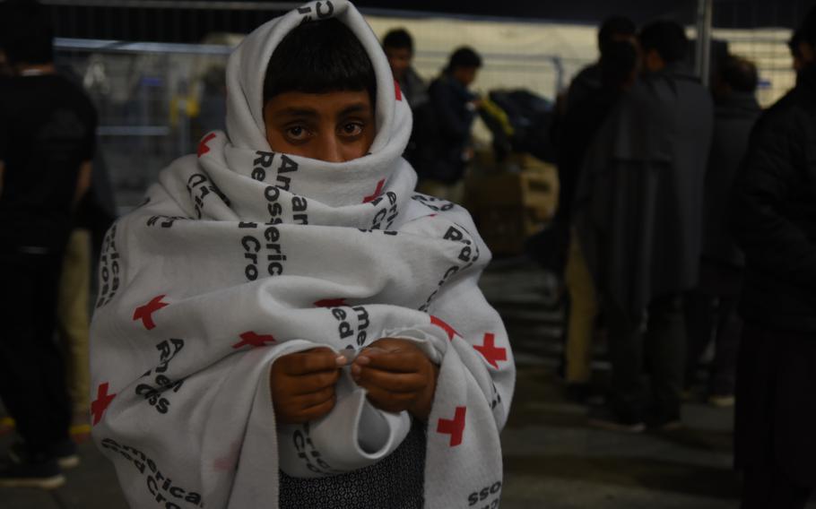 An Afghan boy keeps warm inside a Red Cross blanket during a recent chilly night inside the temporary living facilities for evacuees from Afghanistan at Ramstein Air Base, Germany, Sept. 2, 2021. 