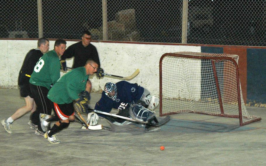 Capt. Ken Schoonover, the goalie and outgoing captain of the U.S. team in the ball hockey league at Kandahar Air Field, makes a kick save during a recent scrimmage of American players in southern Afghanistan.