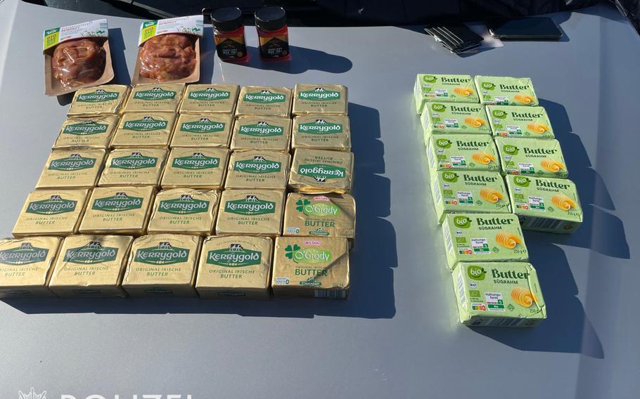 Packs of butter are lined up on a table.