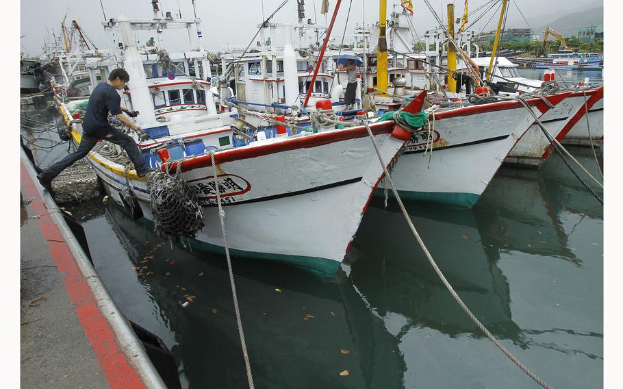 A fisherman leaps to his boat docked in harbor in Toucheng, north eastern Taiwan, Aug. 21, 2013. Taiwan said the Chinese coast guard boarded a Taiwanese fishing boat Tuesday, July 2, 2024, before steering it to a port in mainland China, and demanded that Beijing release the vessel.