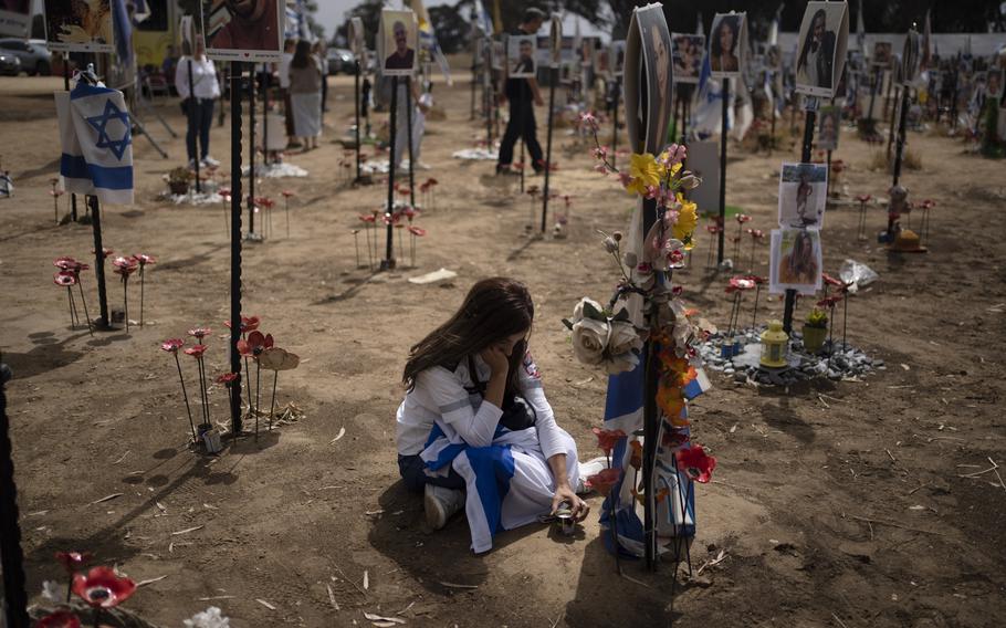 A woman kneels and grieves at the memorial.