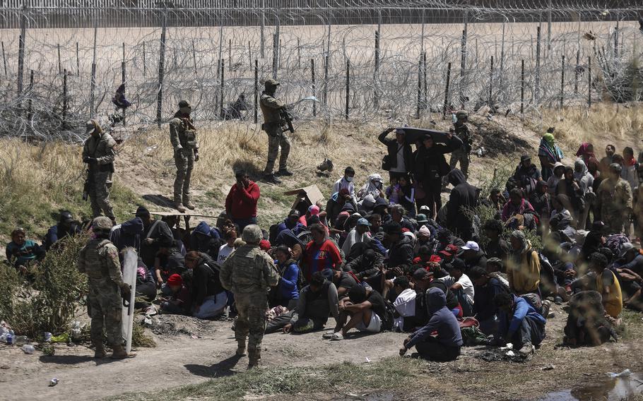 Migrants pray near Texas National Guard