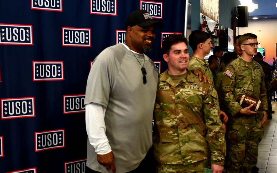 A retired football player poses for photos on a USO tour in Italy.