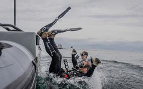 U.S. Navy explosive ordnance disposal technicians dive in the Atlantic Ocean on July 24, 2024. Divers and military personnel who work with explosives have some of the highest suicide rates in the armed forces, the Defense Department found.