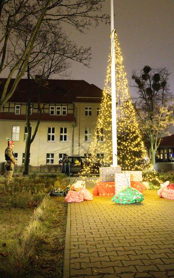 A “Military Police Elf” stands ready by the Christmas tree, awaiting Santa’s orders,