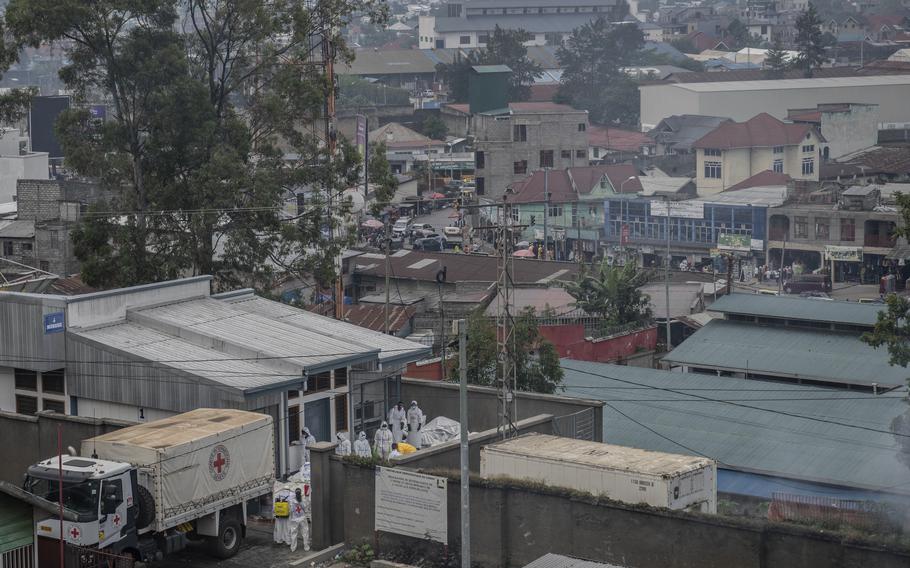 Red Cross personnel load bodies of victims of the fighting between Congolese government forces and M23 rebels in a truck in Goma, Monday,