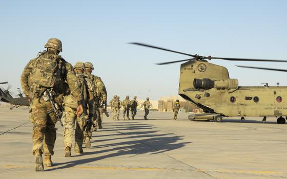 Georgia Army National Guard soldiers enter a CH-47 Chinook helicopter during a training mission in western Iraq on Oct. 30, 2024. They are part of a coalition to prevent a resurgence of the Islamic State group in Iraq and Syria. U.S. forces have repeatedly come under attack by militants in the two countries over the past year.