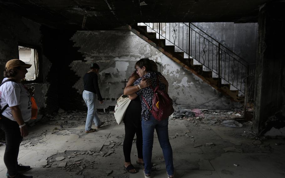 People hug each other at the home of Israelis killed a year ago during the Hamas attack.