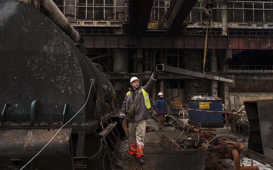 A worker lowers a metal bar to the ground using a crane during repairs to DTEK's power plant after a recent Russian missile attack in Ukraine, Nov. 28, 2024. (AP Photo/Evgeniy Maloletka)