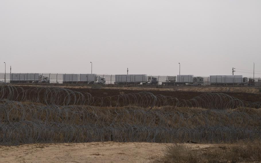 Trucks carrying humanitarian supplies for the Gaza Strip wait in line on the Egyptian side of the Kerem Shalom Crossing, as seen from southern Israel on April 25, 2024.