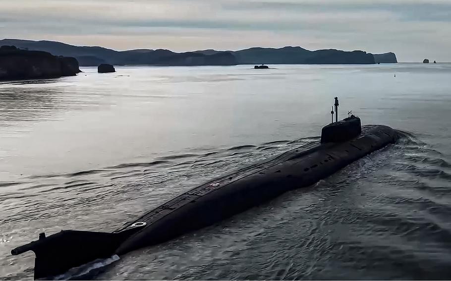 The top half of a submarine appears above the water line as it sails.