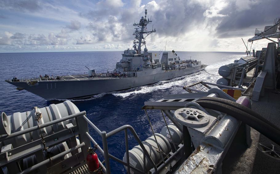 The Arleigh Burke-class, guided-missile destroyer USS Spruance sails alongside the Nimitz-class aircraft carrier USS Abraham Lincoln.