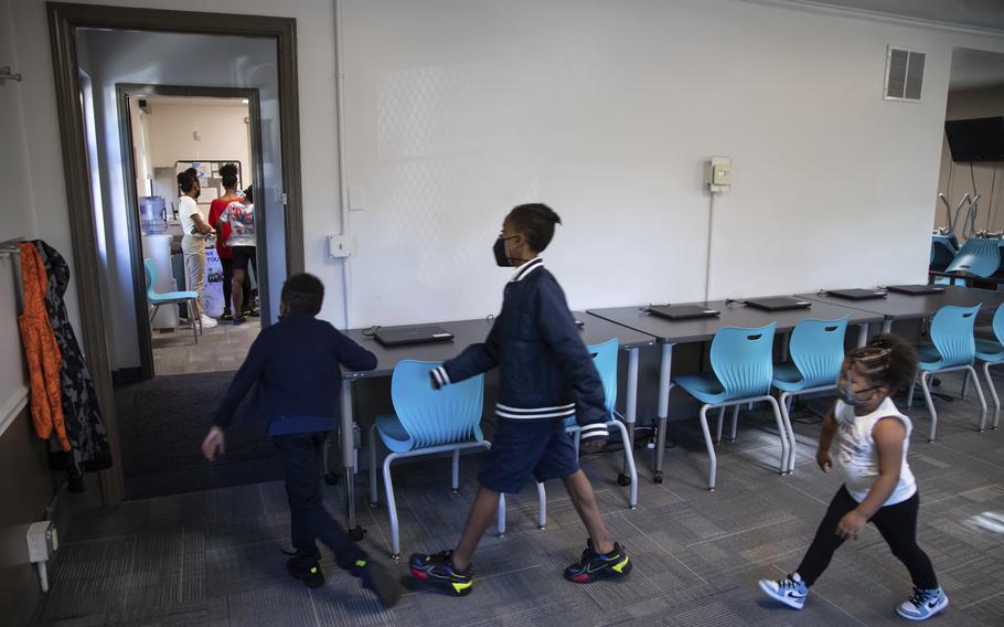 In this Oct. 1, 2021, photo, Zihare Wellons, 7, from left, Shahif Wellons, 12, and Janiyah Acie, 3, walk through new Rec2Tech space at Jefferson Recreation Center, which will provide access to technology and innovative programming for community members including STEM, computer science and coding education, combined with the arts in Pittsburgh. 