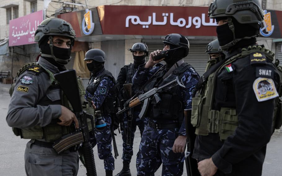 Officers with Helmets, masks, guns and body armor.