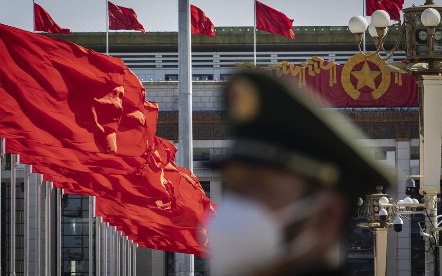 A member of the Chinese People’s Armed Police Force stands guard as a Chinese national flag flies over Tiananmen Square along with other red flags ahead of the fifth plenary session of the First Session of the 14th National People’s Congress (NPC) in Beijing, China, on Sunday, March 12, 2023.