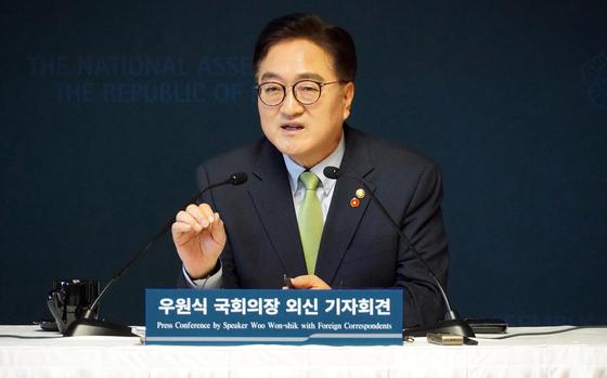 South Korean National Assembly Speaker Woo Won-shik sits at a table speaking into a microphone.