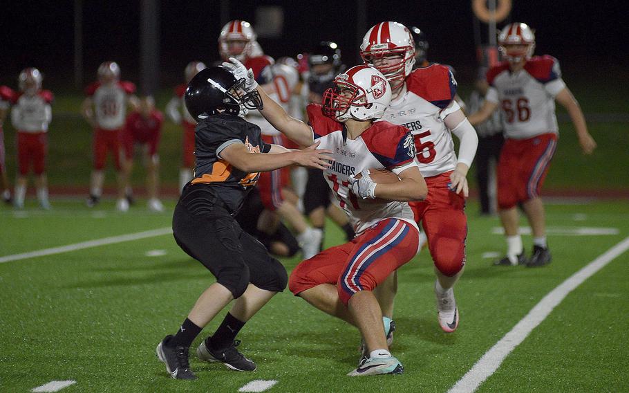 International School of Brussels running back Jonathan Cornet stiff-arms Spangdahlem defender Mason Knight during a Sept. 21, 2024, game at Spangdahlem High School in Spangdahlem, Germany.