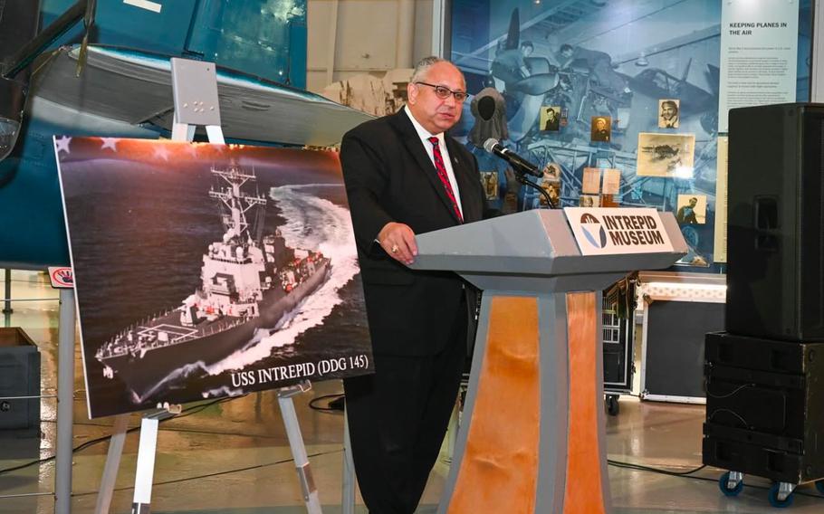 Carlos Del Toro speaks at a podium