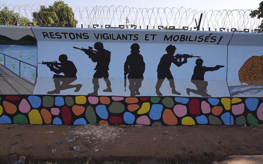 A mural shows the silhouettes of soldiers in different positions.