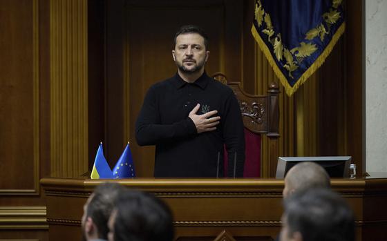 Volodymyr Zelenskyy places his hand over his heart as he listens to the Ukrainian national anthem.