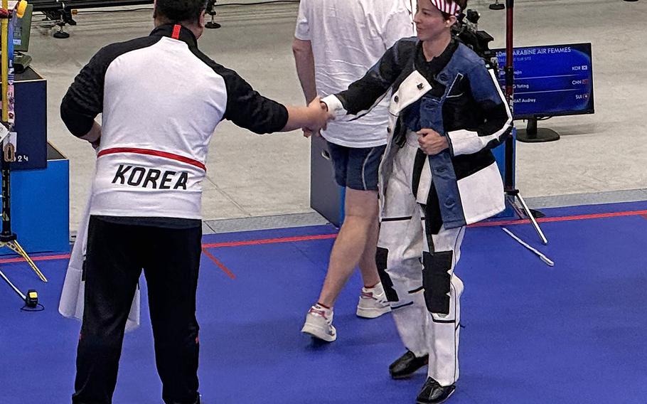 Army Sgt. Sagen Maddalena shakes the hand of a South Korean coach following the conclusion of the women's 10-meter air rifle event on Monday, July 29, 2024, at the Chateauroux Shooting Centre in Chateauroux, France.