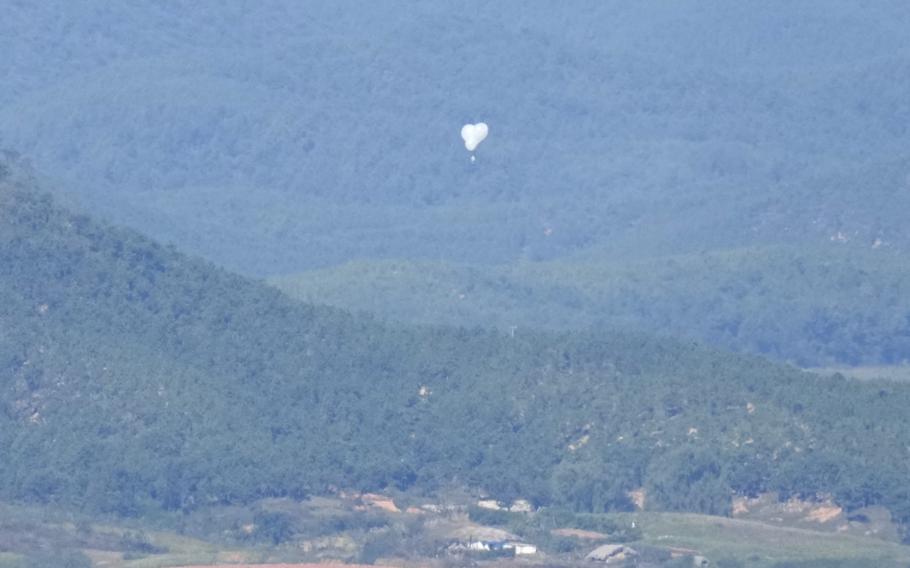 A balloon possibly carrying trash flies over land near South Korea.