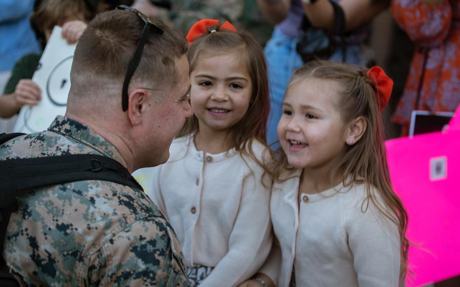 Marines embraces his daughters