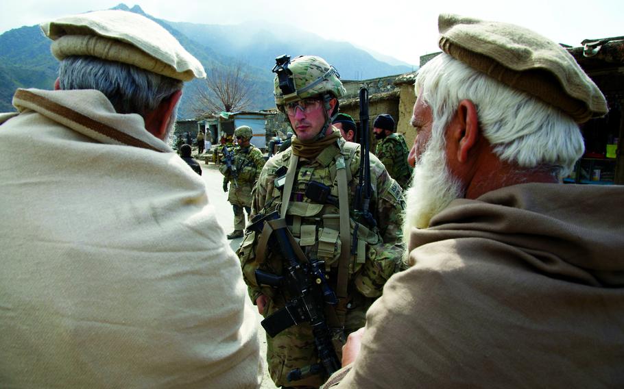 A soldier talks with locals in Afghanistan