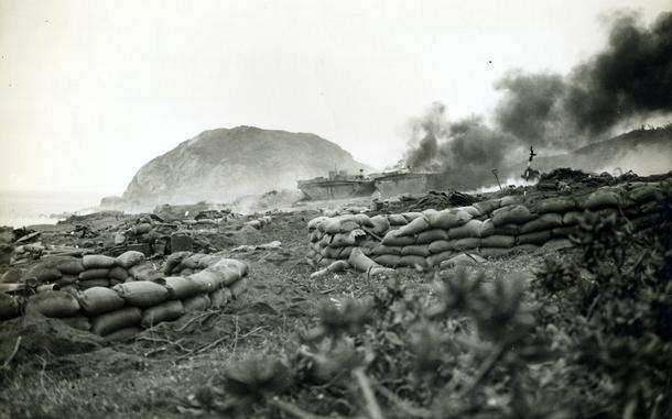 Marine amphibious tractors burn after being hit by Japanese mortar shells during the Battle of Iwo Jima in 1945.