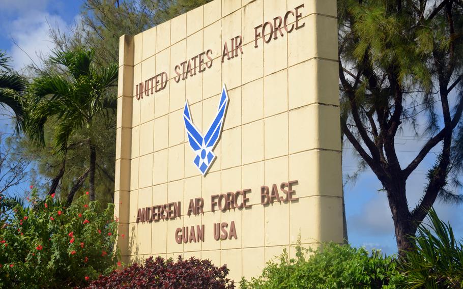 A welcome sign for Andersen Air Force Base on Guam, surrounded by trees and bushes.