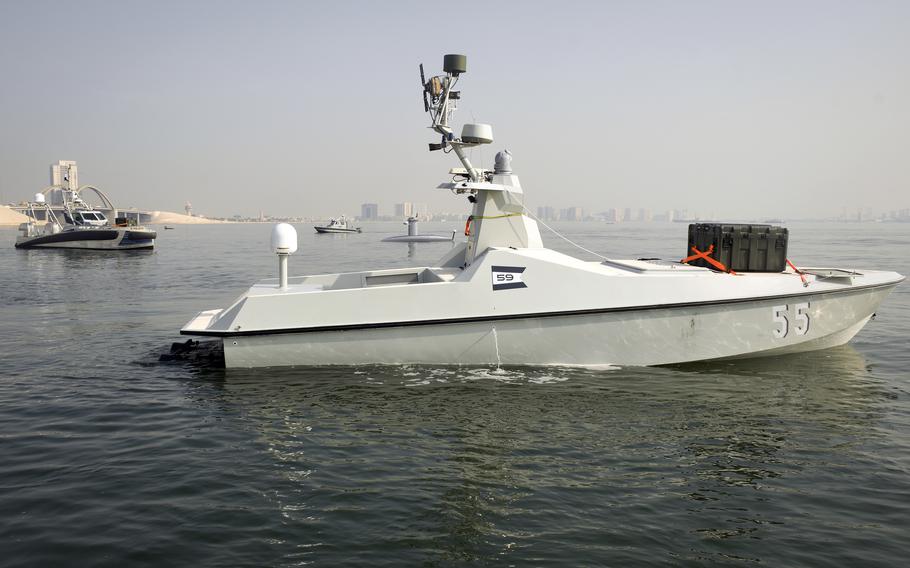Unmanned ships with green boxes containing aerial drones prowl the waters near Naval Support Activity Bahrain on Dec. 1, 2022, as part of an exercise that was the first test for 10 systems by the U.S. 5th Fleet. The U.S. Navy failed to meet its much-touted goal of putting together a fleet of 100 drone boats in the Middle East.