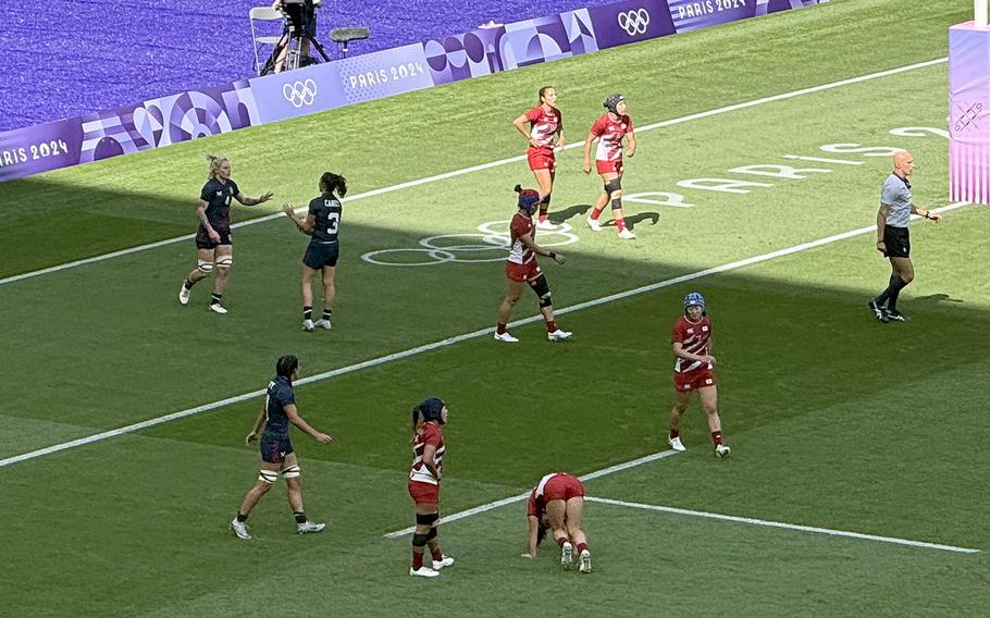 U.S. Army Capt. Sammy Sullivan, upper left, celebrates with Olympic teammate Kayla Canett after scoring a try at the end of the first half of the Eagles' 36-7 win over Japan on July 28, 2024, at Stade de France in Saint-Denis, France.