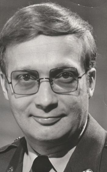 A B/W headshot shows a  man wearing an Army uniform. 