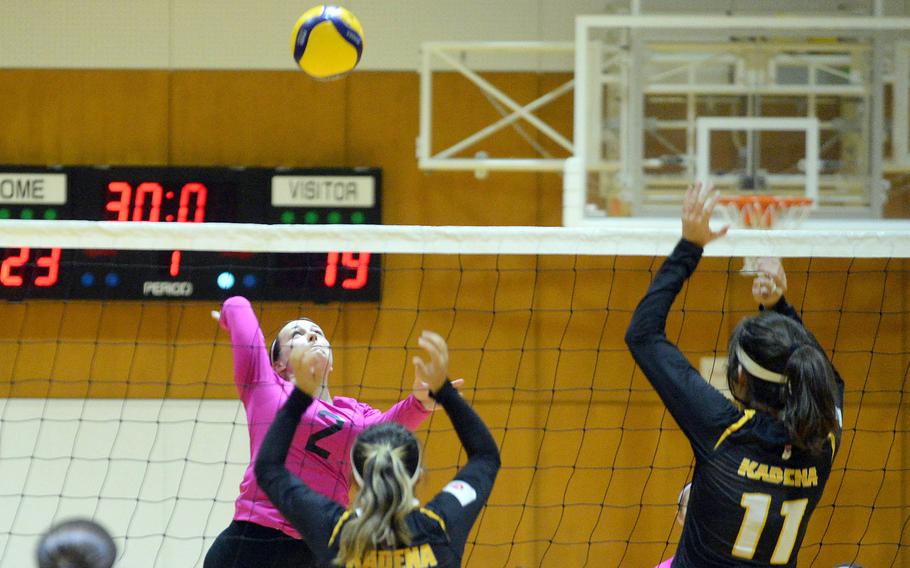 Yokota's Malia Hutchins spikes against Kadena's Lia Connolly and Leighton Botes during Thursday's American School In Japan YUJO tournament match. Yokota won in straight sets.