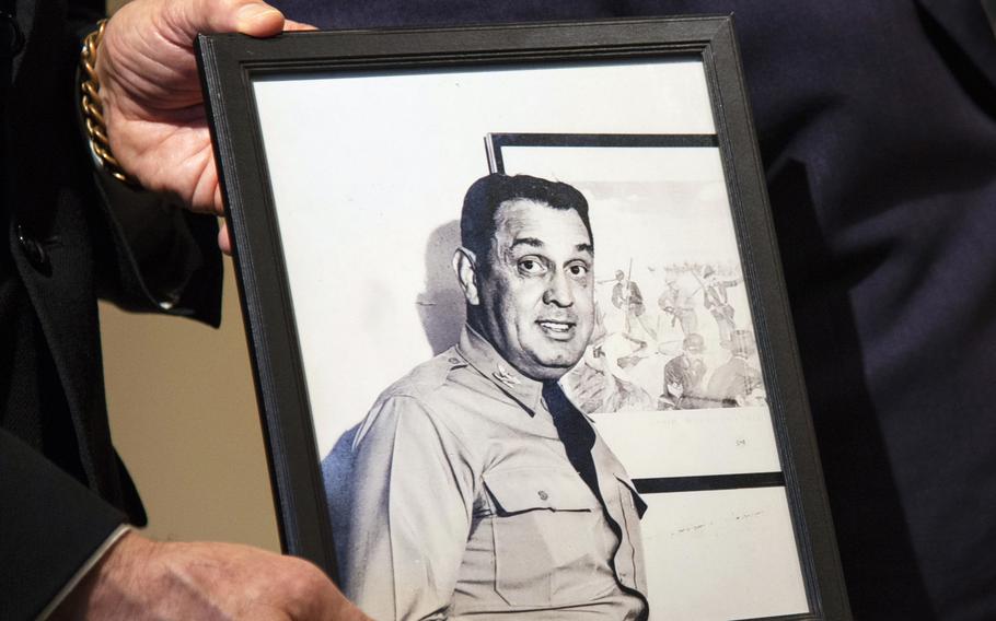 A portrait of U.S. Army Col. Thomas Rogers is held during a ceremony.