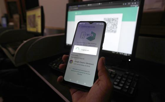 FILE -A Pakistani waits to connect his mobile WhatsApp with a desktop as internet runs slow past several days, in Karachi, Pakistan, Aug. 19, 2024. (AP Photo/Fareed Khan, File)