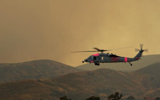 A MH-60S Sea Hawk helicopter assigned to Helicopter Sea Combat Squadron (HSC) 3 takes off to assist in aerial firefighting in Camp Pendleton, Calif. HSC-3 is assisting California Department of Forestry and Fire Protection by providing aircrews flying specially-equipped MH-60S helicopters to conduct aerial water drops against wildfires in San Diego County. (U.S. Navy photo by Mass Communication Specialist 1st Class Joan E. Jennings/Released)