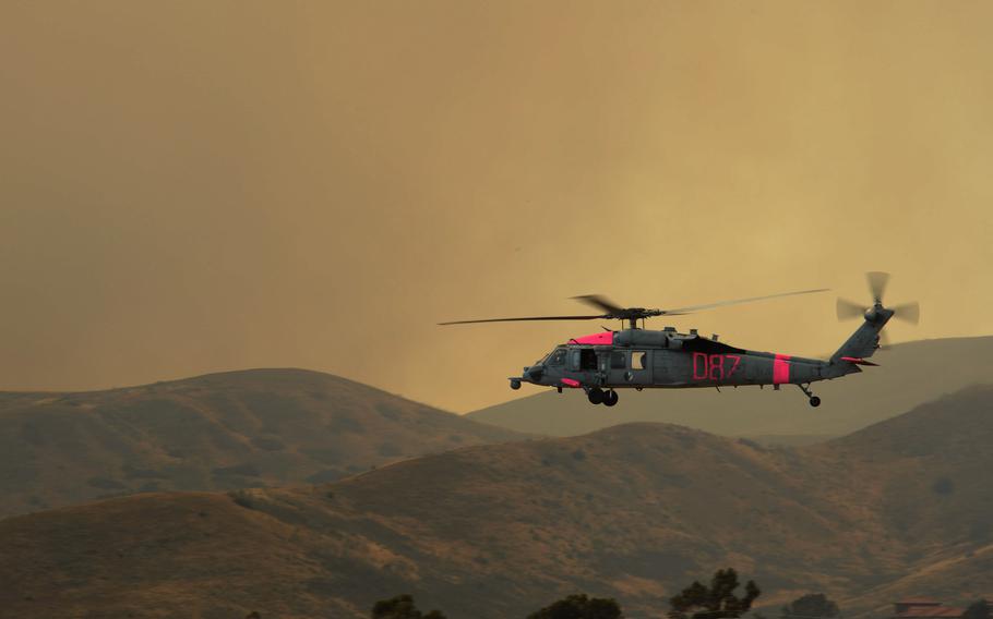 Navy helicopter flying over California mountains.