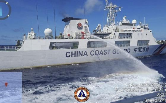 FILE - In this handout photo provided by the Philippine Coast Guard, a Chinese coast guard ship uses water canons on a Philippine Coast Guard ship near the Philippine-occupied Second Thomas Shoal, South China Sea as they blocked it's path during a re-supply mission on Aug. 5, 2023. (Philippine Coast Guard via AP, File)