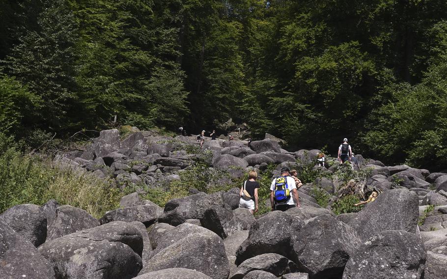 Hikers begin their climb up the Felsenmeer, or "sea of stones," in the Odenwald near Lautertal, Germany, on July 30, 2024. The geological feature stretches a little over a half-mile and climbs over 1,600 feet in elevation. 