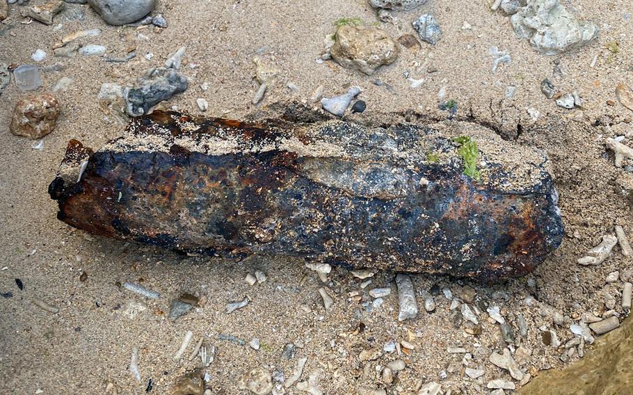 A U.S.-made shell believed to be from World War II sits in the mud.