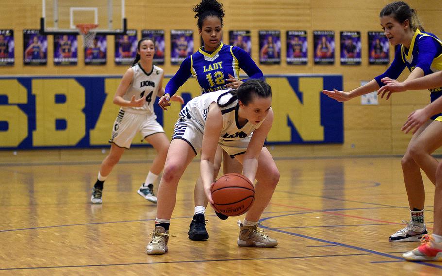 AFNORTH senior Isabella Guest goes low to pick up the ball while Sigonella’s Alysia Dobbins defends during a Division III semifinal at the DODEA European Basketball Championships on Feb. 16, 2024, at Wiesbaden High School in Wiesbaden, Germany.