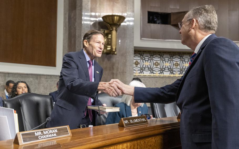 Collins and Blumenthal shake hands.